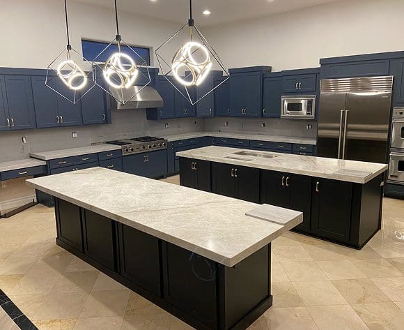 Modern kitchen with two large islands and blue cabinets.