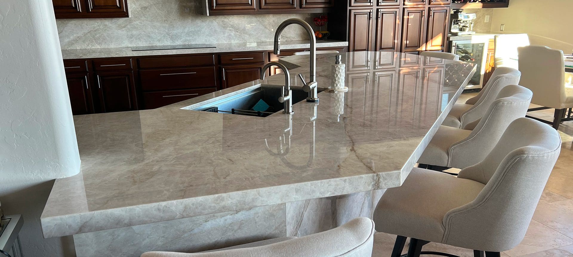 Elegant marble kitchen countertop with modern faucet and soap dispensers.