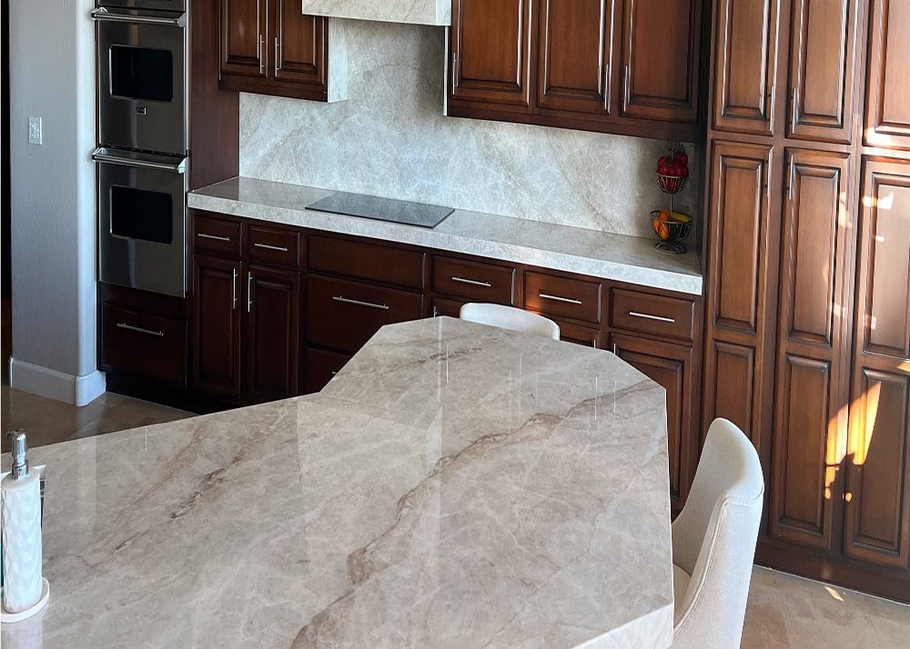 Elegant kitchen with marble countertops and dark wooden cabinets.