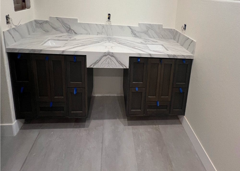 Marble countertop with dark wooden cabinets in a modern bathroom.