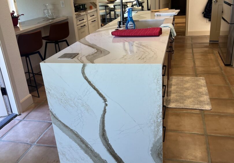 Modern kitchen island with marble countertop and built-in sink.